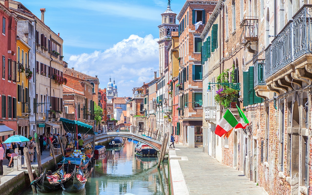 Venice canal with gondolas and colorful buildings on a walking tour route.