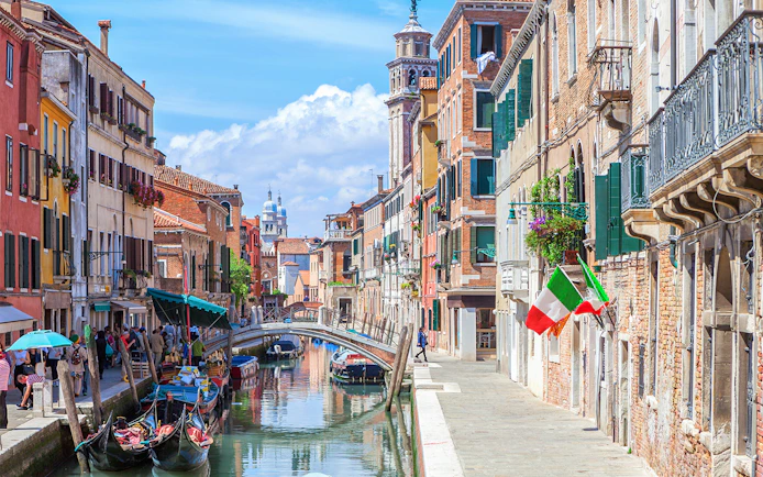 Venice canal with gondolas and colorful buildings on a walking tour route.