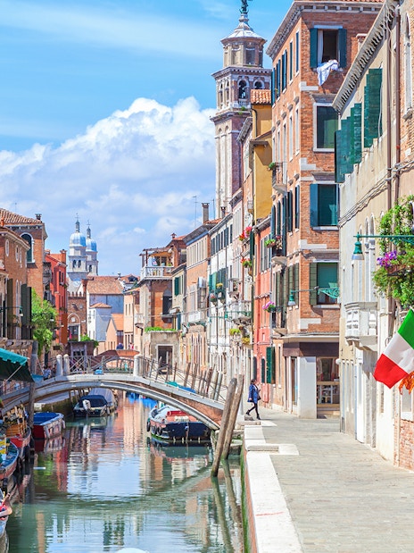 Venice canal with gondolas and colorful buildings on a walking tour route.