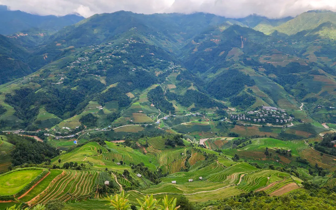 Terraced rice fields and villages in Mu Cang Chai, Vietnam, viewed from above.