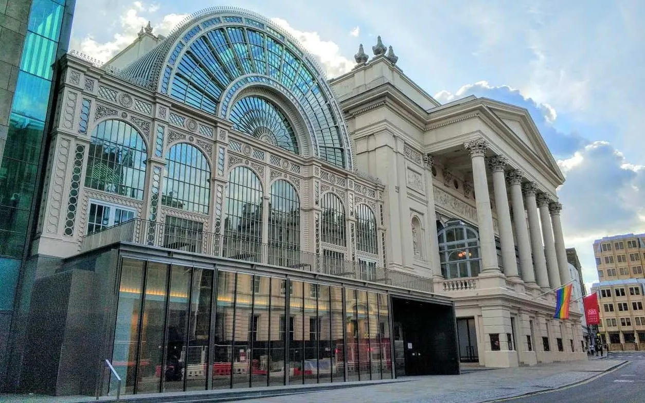 Royal Opera House in London with rainbow flag, part of LGBTQ city exploration game.