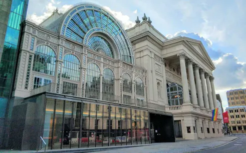 Royal Opera House in London with rainbow flag, part of LGBTQ city exploration game.