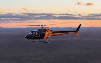 Helicopter flying over Uluru and Kata Tjuta at sunset during a 36-minute tour.