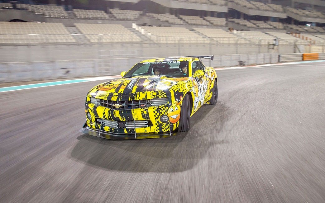 Chevrolet car drifting at Yas Marina Circuit during passenger experience.
