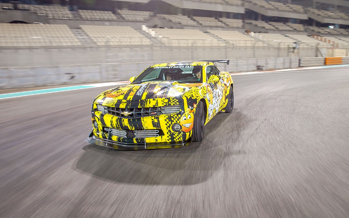 Chevrolet car drifting at Yas Marina Circuit during passenger experience.