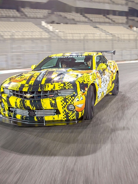Chevrolet car drifting at Yas Marina Circuit during passenger experience.
