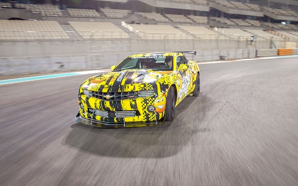 Chevrolet car drifting at Yas Marina Circuit during passenger experience.