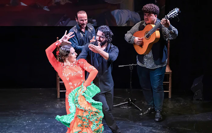 Flamenco dancers and guitarist performing at Teatro Flamenco Triana.