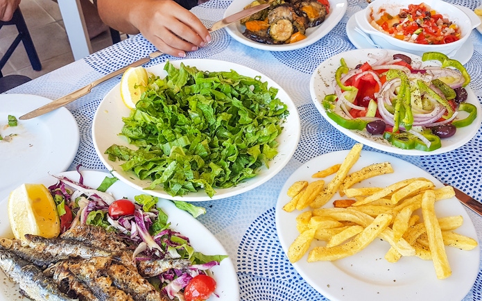 Lunch spread with grilled fish, salad, fries, and vegetables during Ancient Mycenae & Nafplion Premium Tour.