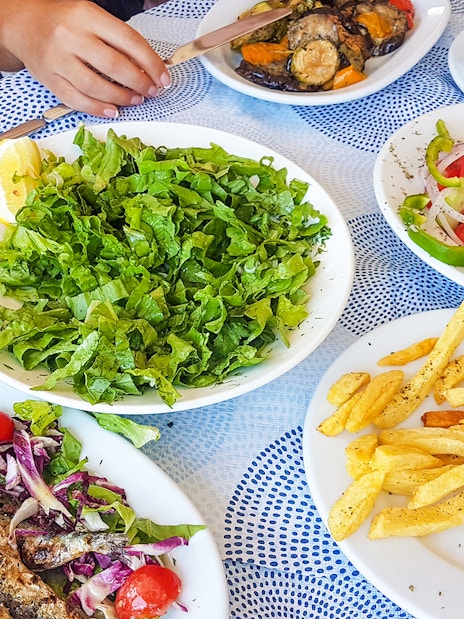 Lunch spread with grilled fish, salad, fries, and vegetables during Ancient Mycenae & Nafplion Premium Tour.