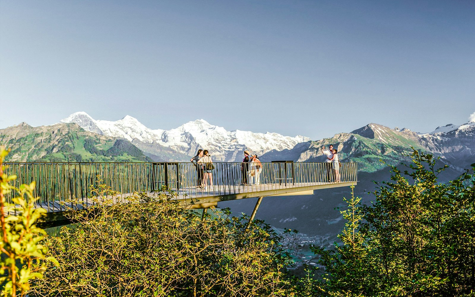 Viewing platform at Harder Kulm with tourists and Swiss Alps in the background.