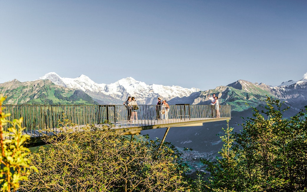 Viewing platform at Harder Kulm with tourists and Swiss Alps in the background.