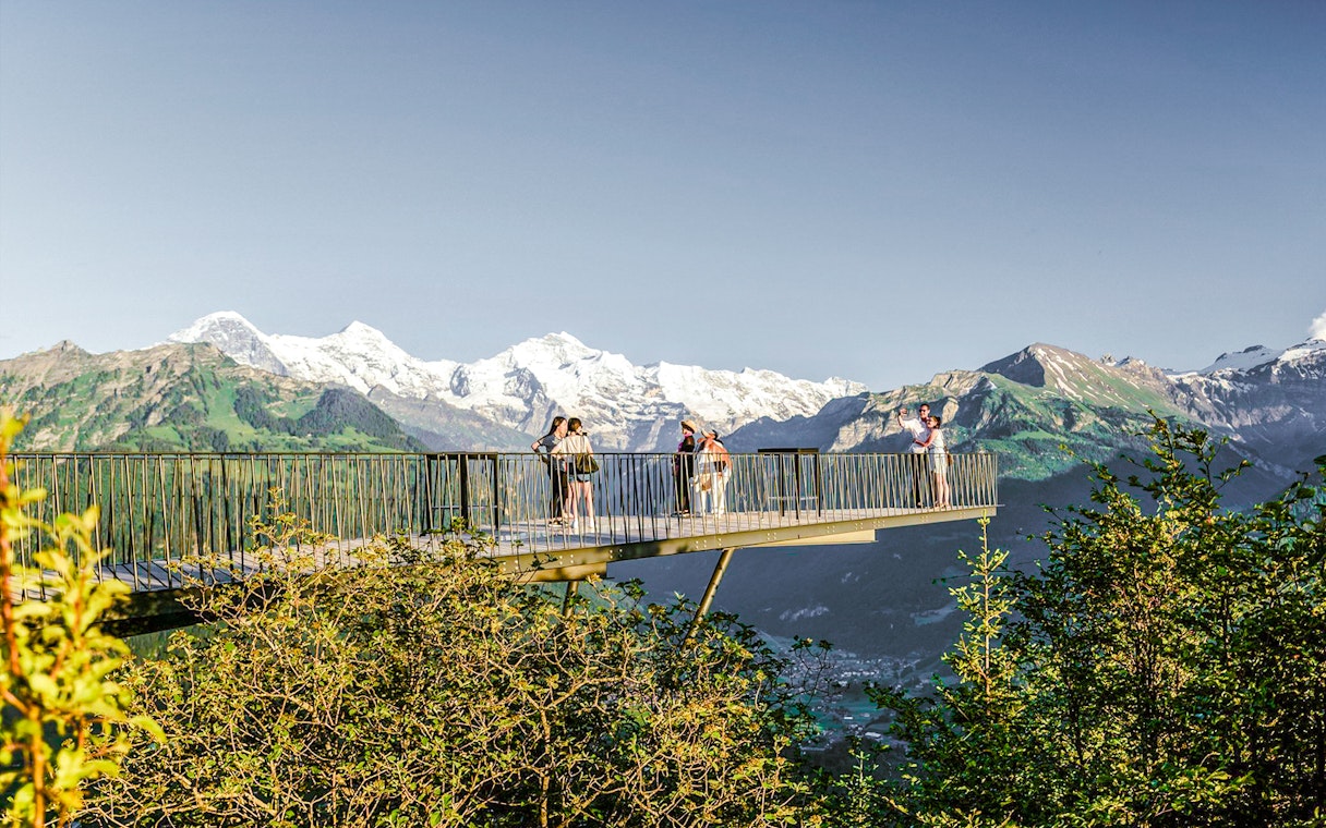 Viewing platform at Harder Kulm with tourists and Swiss Alps in the background.
