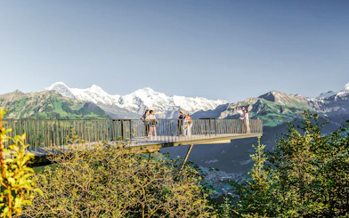 Viewing platform at Harder Kulm with tourists and Swiss Alps in the background.