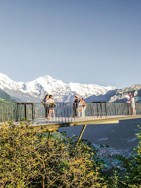 Viewing platform at Harder Kulm with tourists and Swiss Alps in the background.