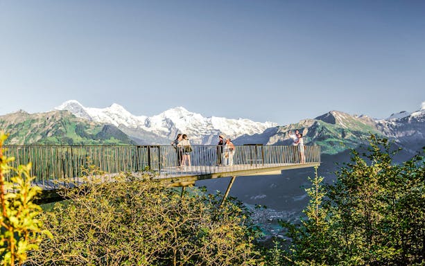 Viewing platform at Harder Kulm with tourists and Swiss Alps in the background.