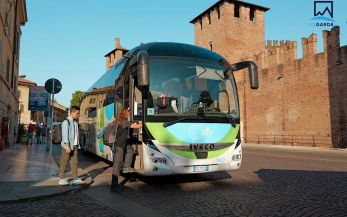 Tourists boarding a bus in Verona for a Dolomites guided tour with village stops.