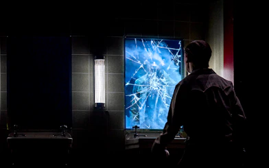 Man facing cracked mirror with reflection, Stranger Things: The First Shadow.
