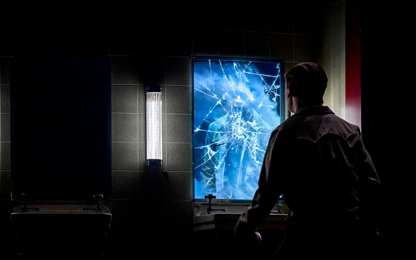 Man facing cracked mirror with reflection, Stranger Things: The First Shadow.