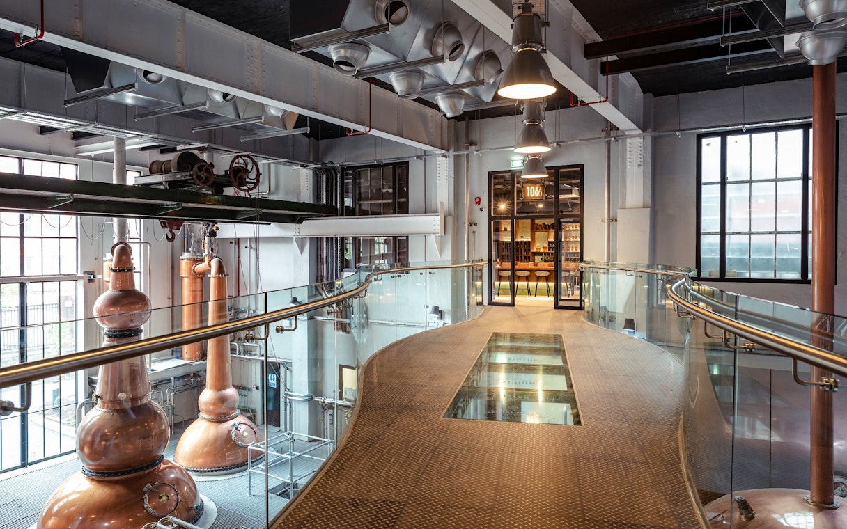 Roe & Co Distillery interior with copper stills and modern walkway.