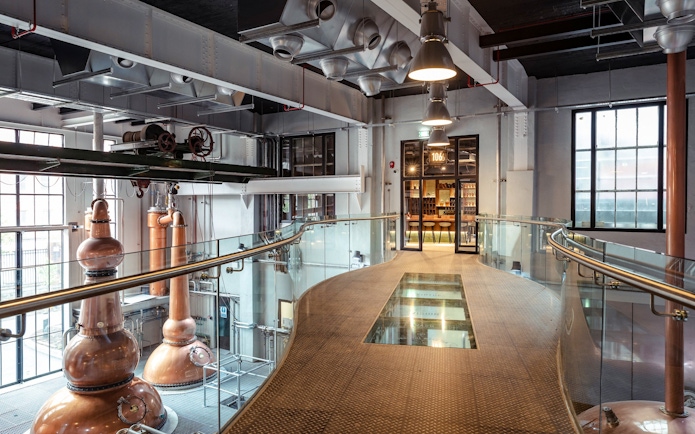 Roe & Co Distillery interior with copper stills and modern walkway.
