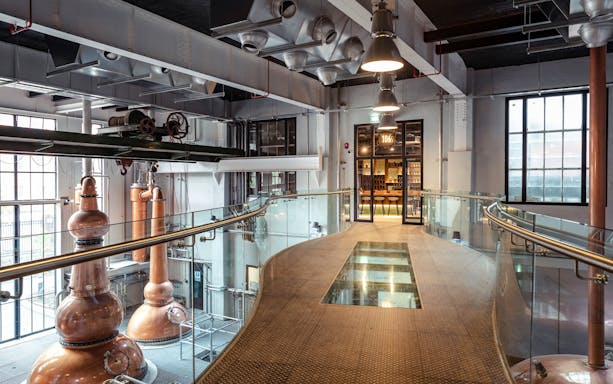 Roe & Co Distillery interior with copper stills and modern walkway.