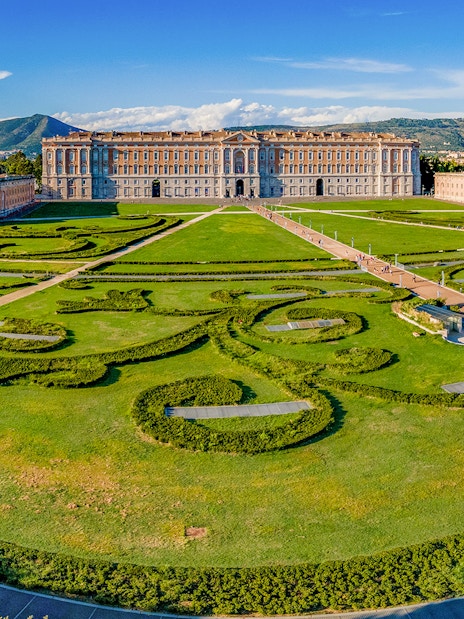 Royal Palace of Caserta with expansive gardens and intricate hedges in Caserta, Italy.