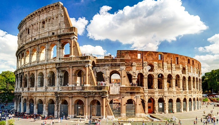 Colosseum in Rome with tourists exploring the ancient amphitheater.