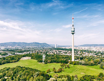 Danube Tower overlooking Vienna cityscape and green parkland.