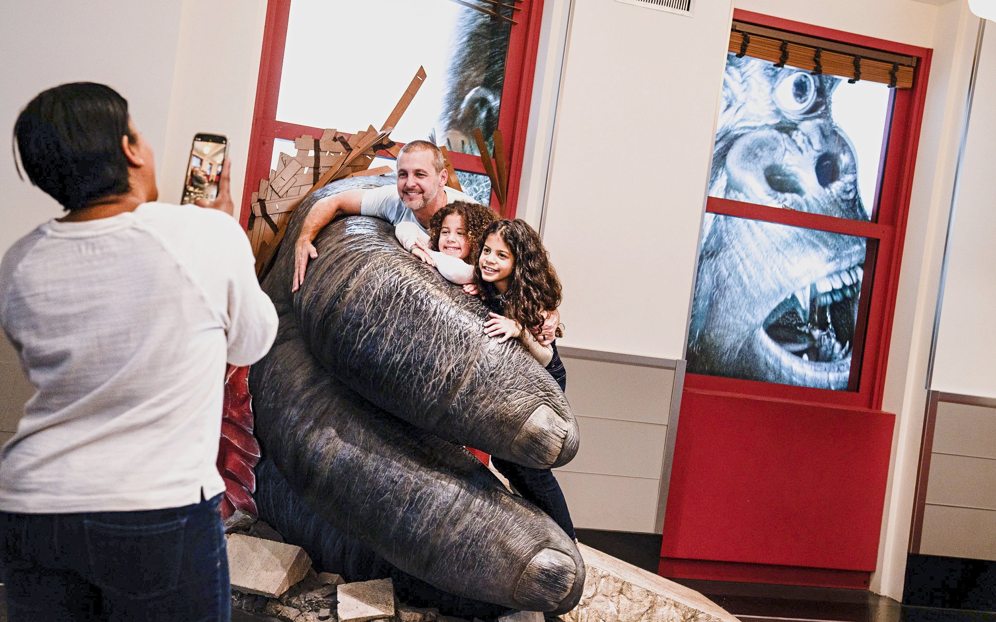 Family posing with King Kong exhibit at Empire State Building.