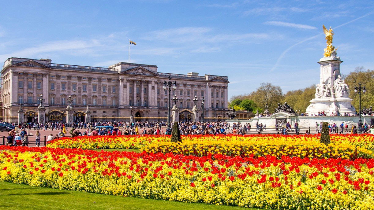 Buckingham Palace with colorful flower gardens and Victoria Memorial in London.