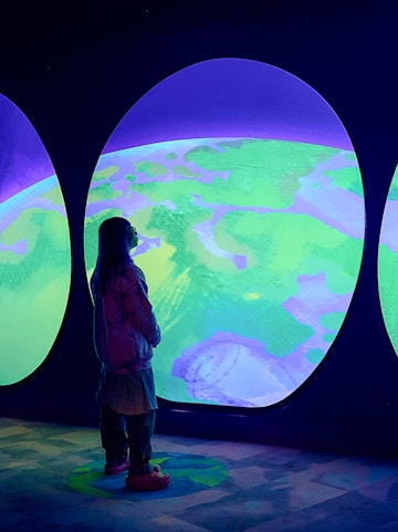Visitor observing Our Wondrous Planet exhibit at Melbourne Museum.