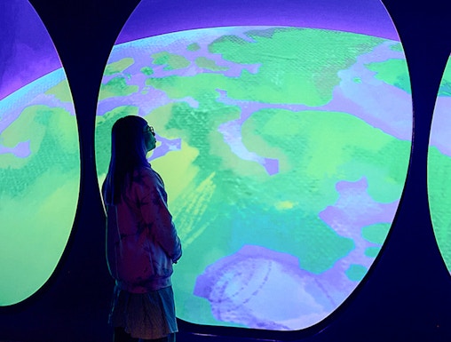 Visitor observing Our Wondrous Planet exhibit at Melbourne Museum.