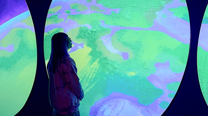 Visitor observing Our Wondrous Planet exhibit at Melbourne Museum.