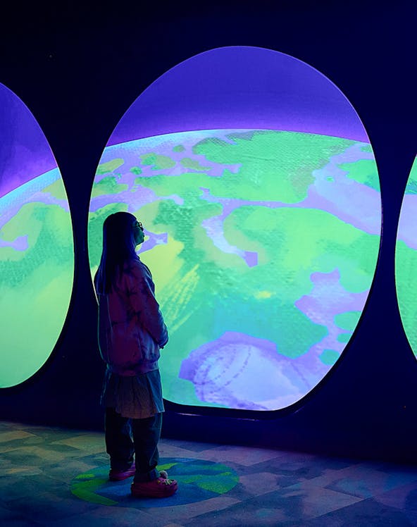 Visitor observing Our Wondrous Planet exhibit at Melbourne Museum.