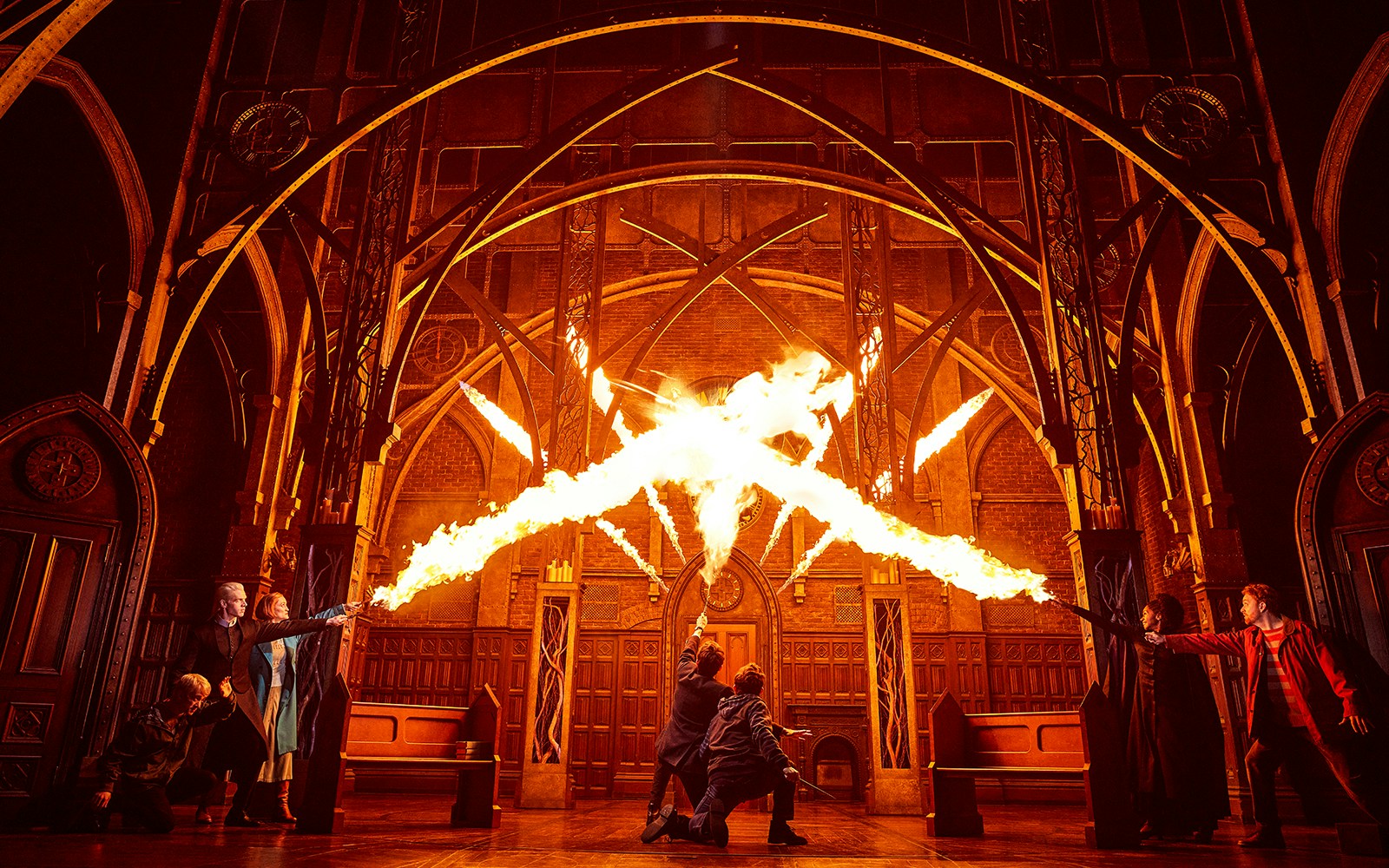 Characters casting spells with fire in a dramatic scene from "Harry Potter and the Cursed Child" stage play.