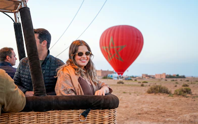 Hot air balloon preparing for sunrise flight in Marrakesh with passengers onboard.