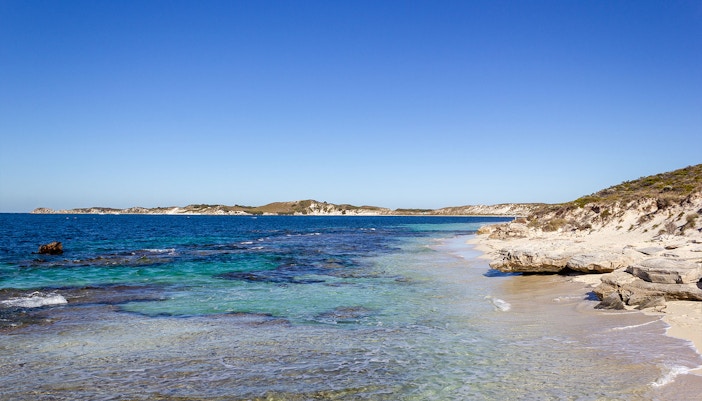 Coastal view of Rottnest Island, Australia, with clear blue water and sandy beach.