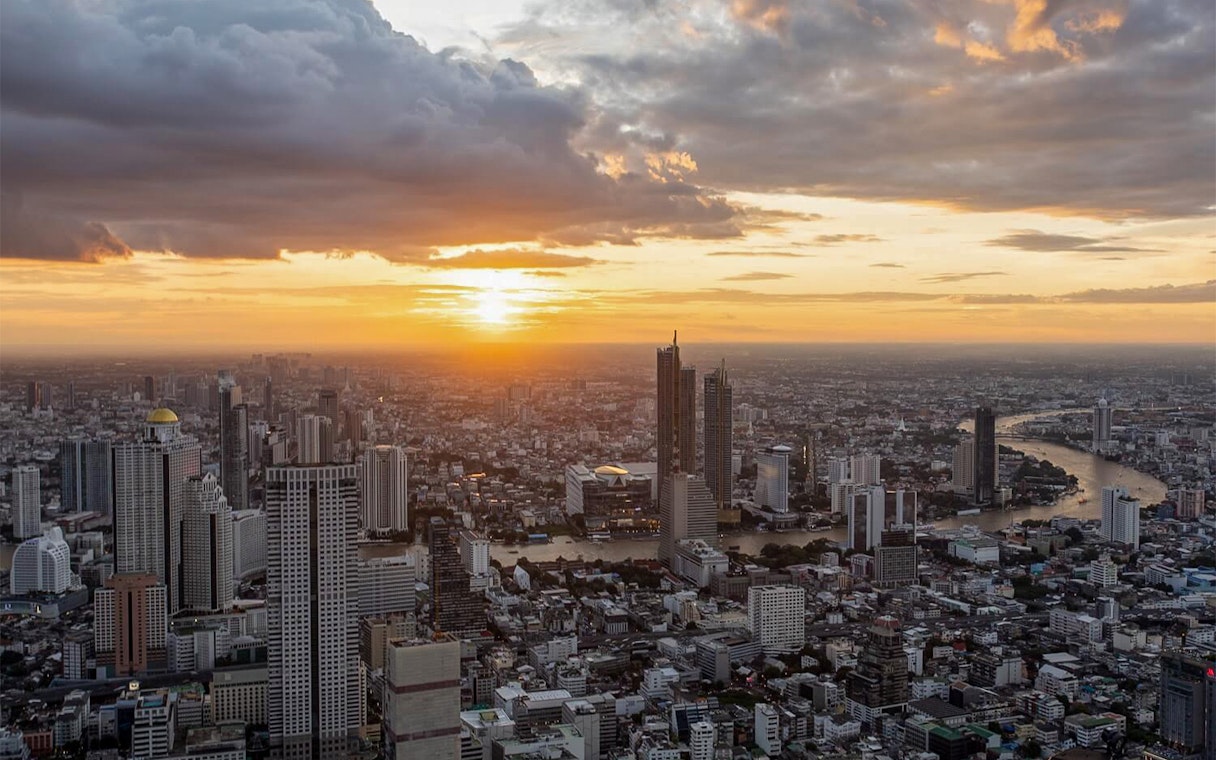 Aerial view of Bangkok skyline from Mahanakhon SkyWalk at sunset.