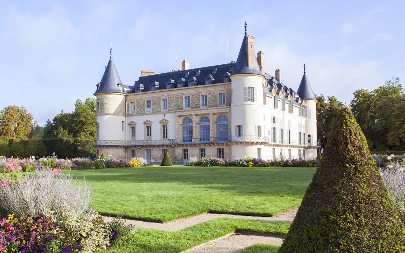 Castle of Rambouillet with gardens and manicured hedges in France.