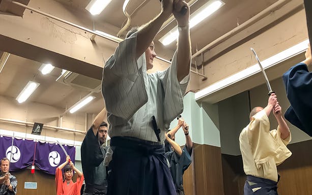 Participants practicing sword techniques during a Samurai experience in Tokyo.