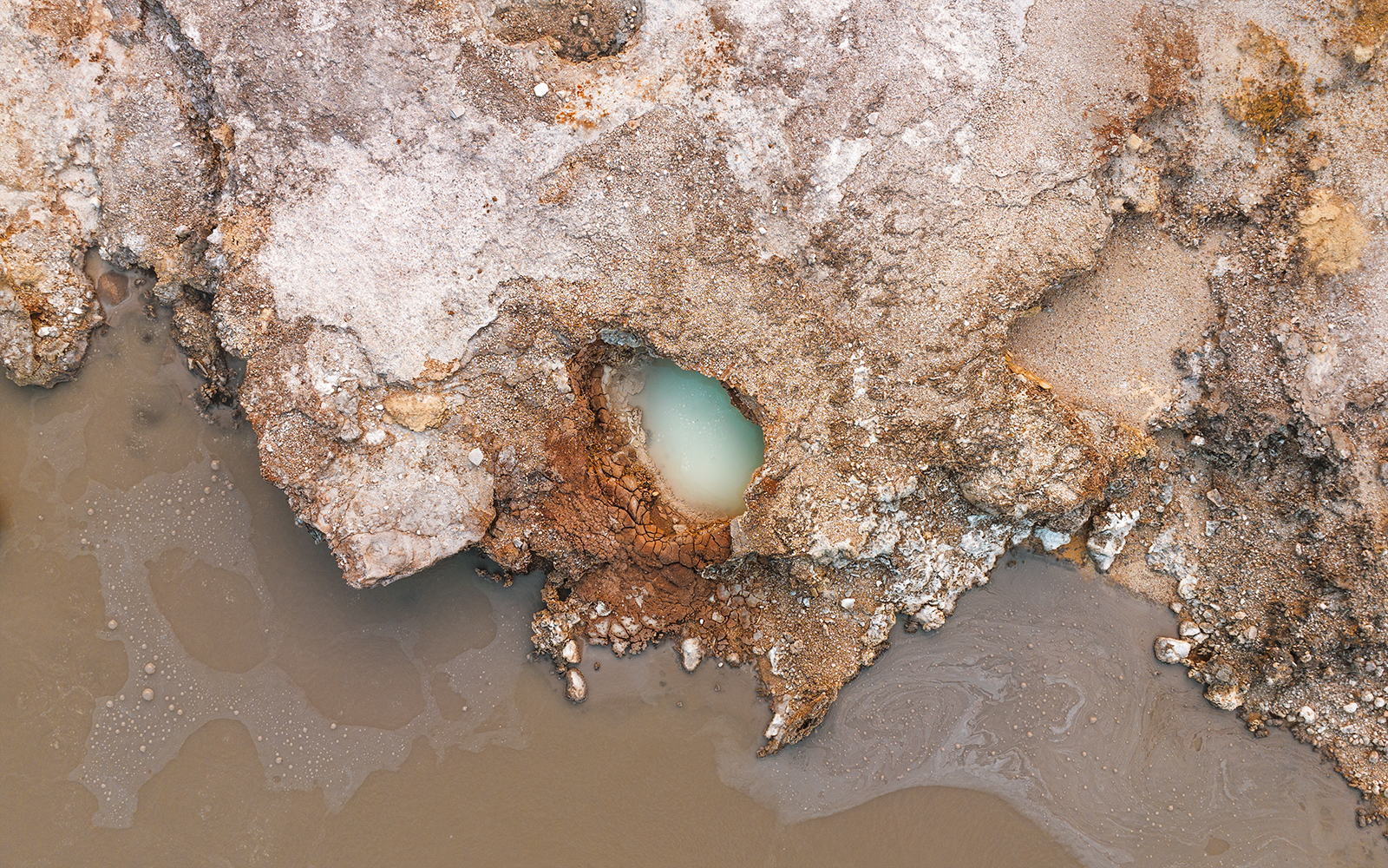 Aerial view of geothermal pool and rocky terrain at Hells Gate Geothermal Walk.