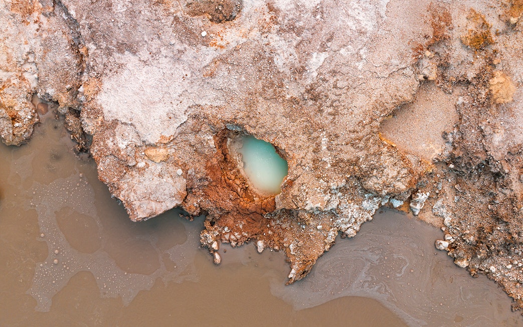 Aerial view of geothermal pool and rocky terrain at Hells Gate Geothermal Walk.