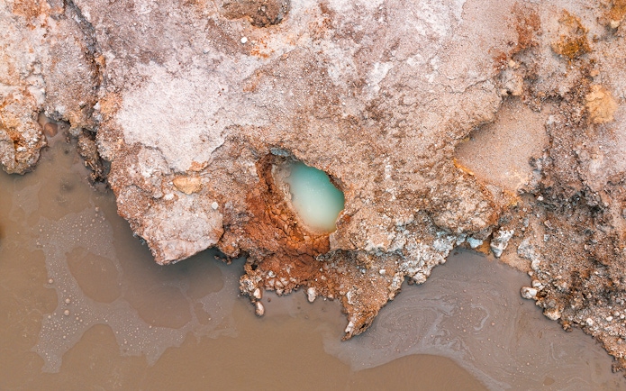 Aerial view of geothermal pool and rocky terrain at Hells Gate Geothermal Walk.