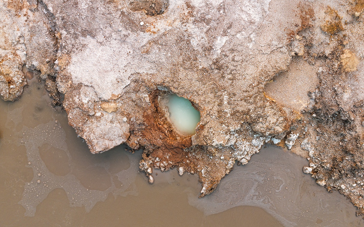 Aerial view of geothermal pool and rocky terrain at Hells Gate Geothermal Walk.