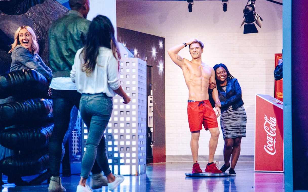 Visitors posing with a wax figure at Madame Tussauds Hollywood.
