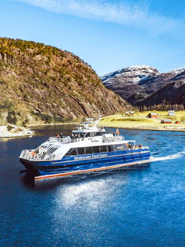 Mostraumen Fjord Cruise boat sailing through scenic Norwegian fjord with mountains.