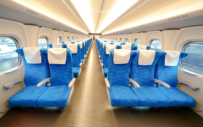 Shinkansen train interior with blue seats and white headrests in Japan.