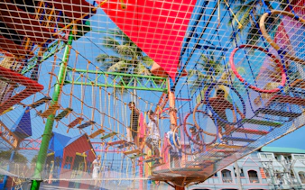 Children navigating colorful ropes course at outdoor adventure park, Phuket.
