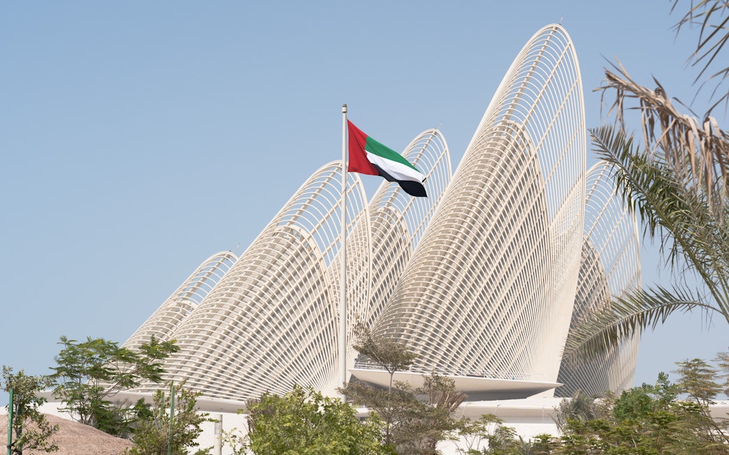 Zayed National Museum exterior with UAE flag in Abu Dhabi.